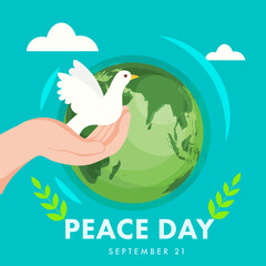 Fototapeta na wymiar Human Hand Holding Pigeon with Olive Leaves and Earth Globe on Turquoise Background for Peace Day, 21st September.
