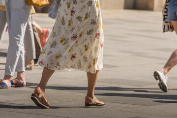 young woman with flowery dress walks