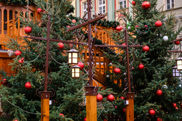 Vintage street lanterns and red christmas balls with LED garlands on decorated natural New Year trees on a festive Christmas fair on central city street.