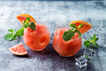 Ruby red grapefruit cocktail with mint leaves in glasses