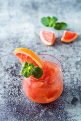 Ruby red grapefruit cocktail with mint leaves in glasses
