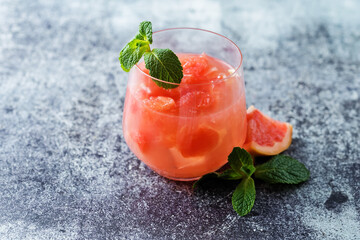 Ruby red grapefruit cocktail with mint leaves in glasses