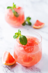 Ruby red grapefruit cocktail with mint leaves in glasses