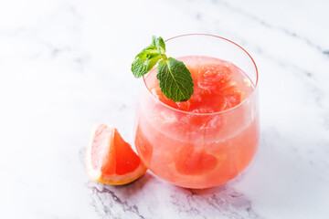 Ruby red grapefruit cocktail with mint leaves in glasses