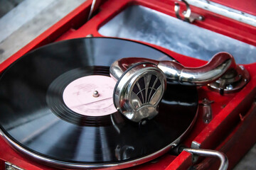 Old red vintage record player with vinyl record. Old style to listen music.