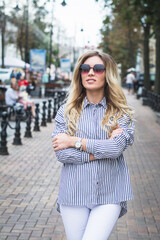 beautiful stylish young girl posing for a photographer on the street