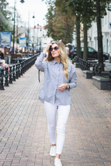beautiful stylish young girl posing for a photographer on the street