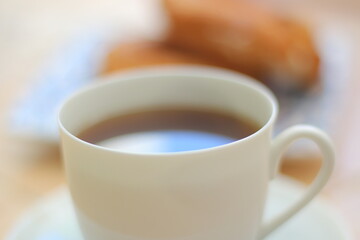 Morning. Espresso coffee in a porcelain cup on a saucer. Cake Ring with cream on a square plate with oriental ornaments