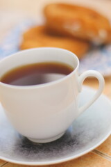 Morning. Espresso coffee in a porcelain cup on a saucer. Cake Ring with cream on a square plate with oriental ornaments