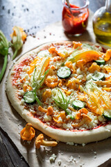 Preparations for homemade pizza made with zucchini flower and mushrooms