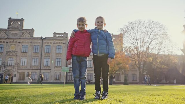 Best friends are hugging. Two cheerful friends posing for photos on the memory. Brothers for a walk in the autumn park. Family vacation, family video. Childhood concept.