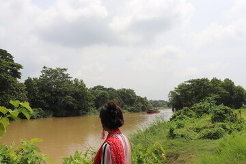 young  woman is  enjoying the beauty of a river