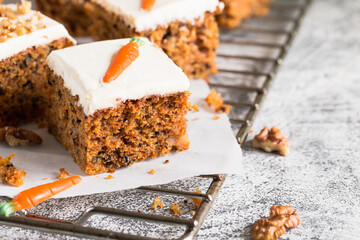 pieces of carrot cake with walnuts with icing cream on a light background. tinting. selective focus