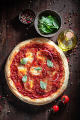 Homemade pizza Pugliese with bolognese sauce, meat, basil and onion