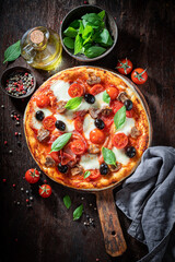 Delicious pizza Capricciosa made of tomatoes, cheese, olives and ham