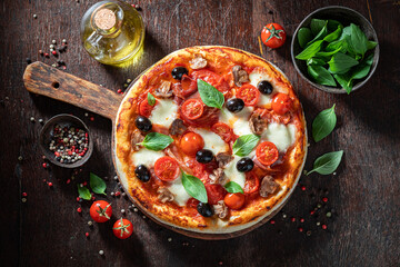 Fresh pizza Capricciosa with prosciutto, cheese and mushrooms