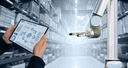 Warehouse manager with digital tablet controls robot arm