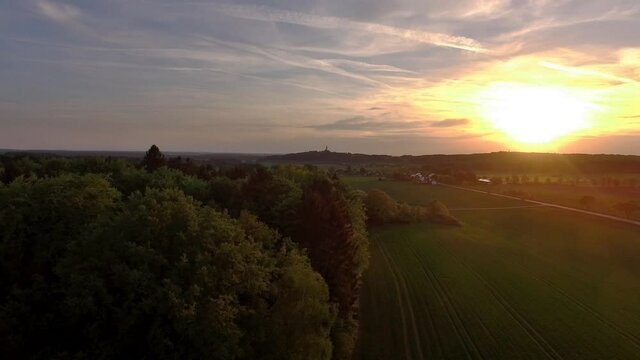Drone is flying above bavarian fields during sunset