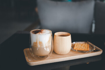 Transparent coffee cup Hot cappuccino on the table in a coffee shop with people.