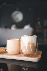 Transparent coffee cup Hot cappuccino on the table in a coffee shop with people.