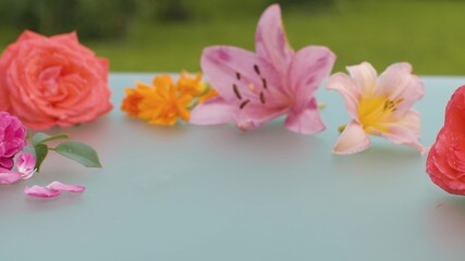 Obraz na płótnie Canvas Roses and lilies on a glass table