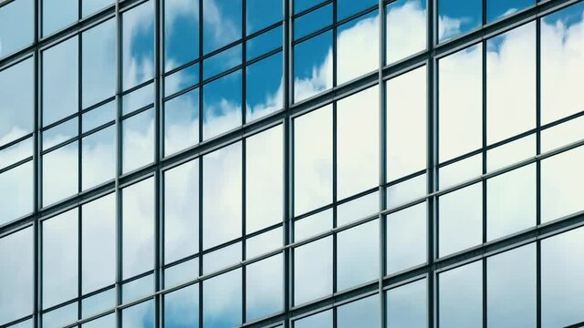 Time lapse of blue sky and clouds reflected in structural modular glass wall. 
