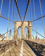 New Yorkers and tourists cross or pass landmark sightseeing Brooklyn Bridge with breathtaking...