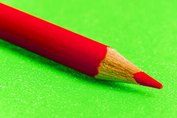 Lapiz de color rojo sobre fondo verde