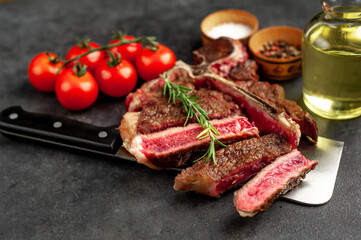 grill t-bone steak with ingredients on a meat knife on stone background