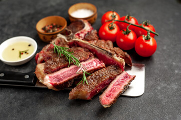 grill t-bone steak with ingredients on a meat knife on stone background