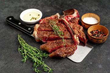 grill t-bone steak with ingredients on a meat knife on stone background