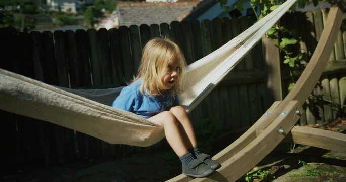 Preschooler sitting in a hammock outdoors