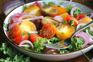 Fresh green salad with cherry tomatoes, cabbage Kale, onions on cutting board. Wooden background