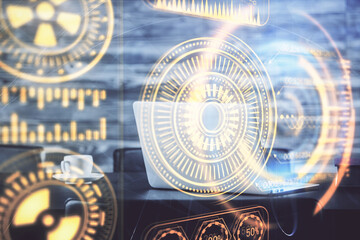 Computer on desktop in office with technology theme hologram. Double exposure. Tech concept.