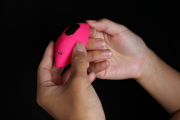 Woman holding her brand new Pink remote controlled silicon vibrator.
