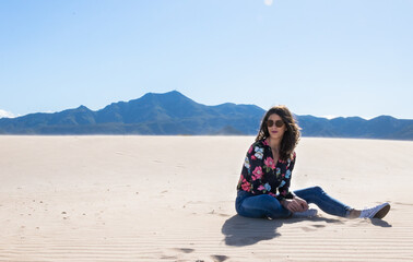 Young woman sitting in the sand on the beach