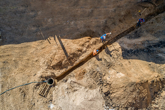 Workers Dig A Trench For Laying Cable Top View.