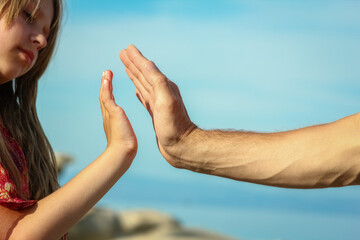 Fototapeta na wymiar beautiful hands of parent and child by the sea