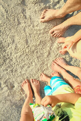 beautiful family legs on the sand by the sea