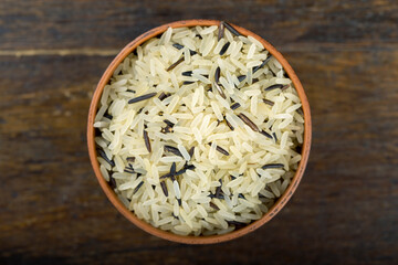 Wild rice in a bowl on a wooden table.