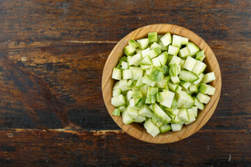 Sliced zucchini in a bowl on a wooden background. Vegetable, ingredient and staple food.