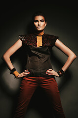 serious woman in brown shirt and red jeans