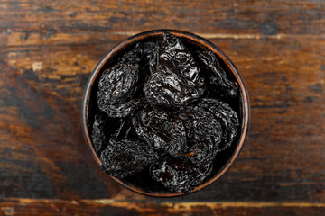Fresh prunes in wooden bowl. Dried plums.