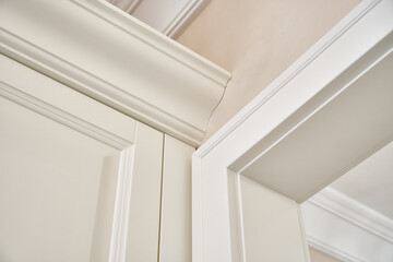 Detail of classic white wardrobe in contemporary bright hallway