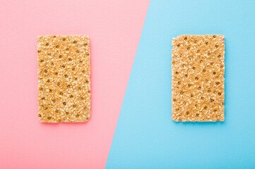 Crispy bread on light pink blue table background. Dietary food. Closeup. Two sides. Top down view.