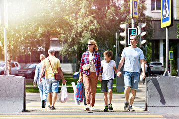 Obraz premium Woman, man and child cross road at crosswalk