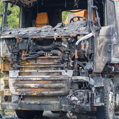 Burnt car on the side of the road. Fully burnt truck cab.