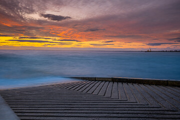Fototapeta na wymiar Boat ramp on ocean shore at sunset - long exposure seascape