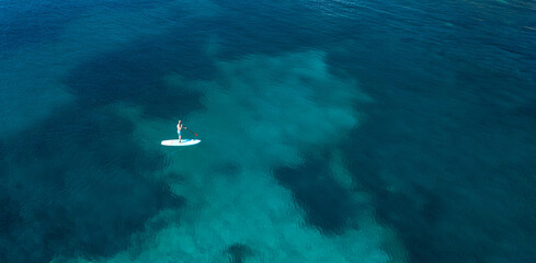 Aerial view of person with stand up puddleboard in the sea.