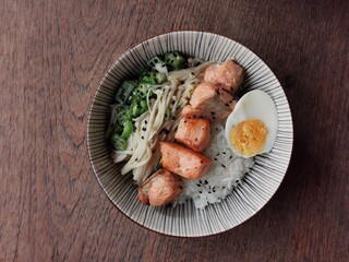 Healthy rice bowl with grilled salmon, boiled egg and stir-fried vegetables